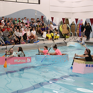  Students in the cardboard boats racing in the pool.